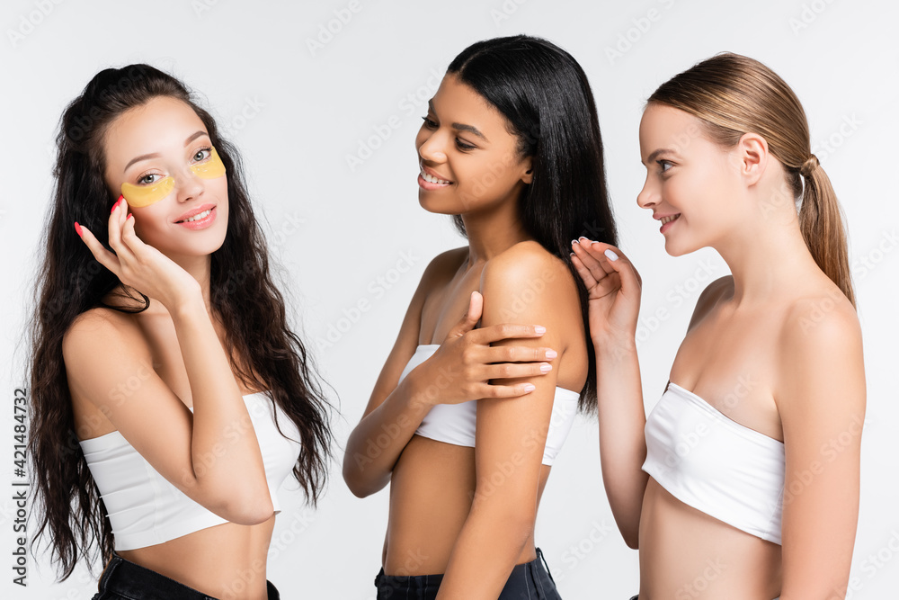 brunette woman with eye patches smiling and looking at camera near multicultural friends isolated on white brunette woman with eye patches smiling and looking at camera near multicultural friends isolated on white