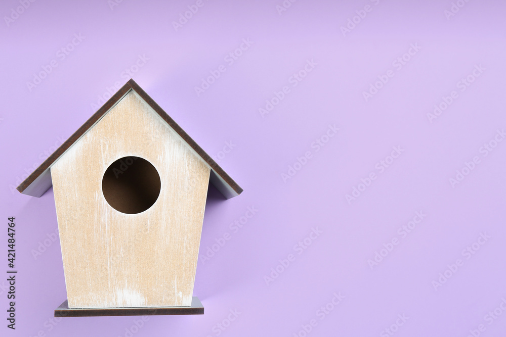 Beautiful bird house on violet background, top view. Space for text Beautiful bird house on violet background, top view. Space for text