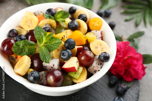 Delicious exotic fruit salad on grey table  closeup