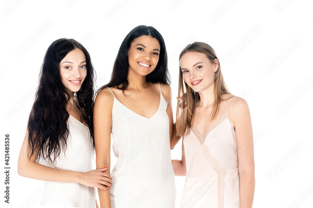 pleased interracial women in dresses smiling isolated on white pleased interracial women in dresses smiling isolated on white
