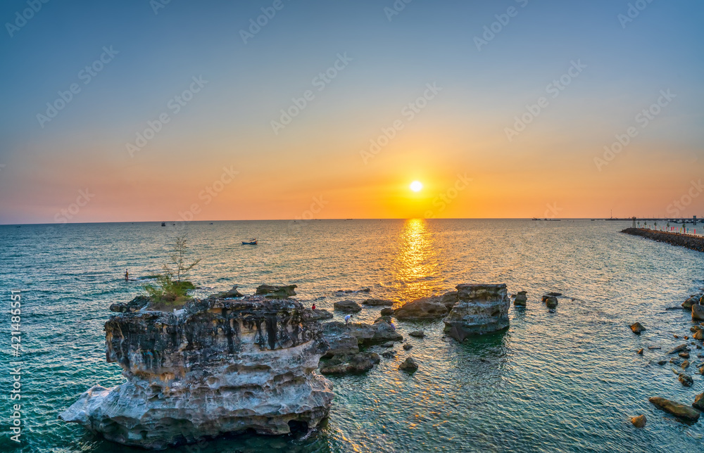 Fototapeta premium Sunset at abstract limestone beach facing the sea in pearl island Phu Quoc, Vietnam. The place remains unspoiled for ecotourism and exploration