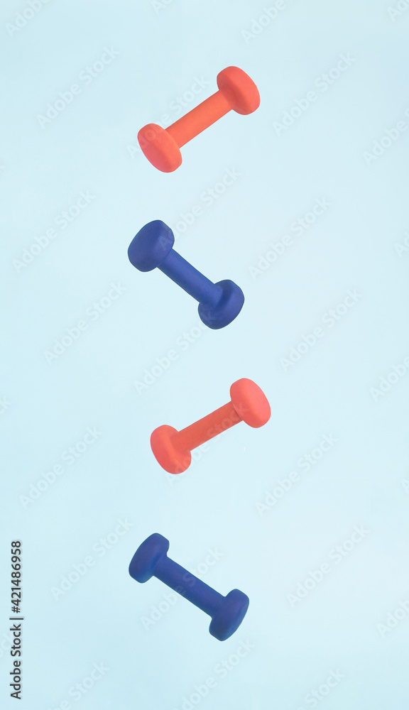 Pink and blue exercise dumbbell weights flying and floating in air in strong graphic line for art fitness concept. Pink and blue exercise dumbbell weights flying and floating in air in strong graphic line for art fitness concept.