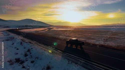 Pickup truck on road during sunrise winter time. Aerial drone footage.