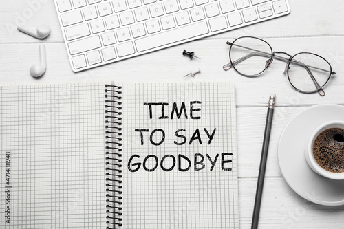 Quadro su tela Notebook with text Time to say goodbye on white wooden table, flat lay