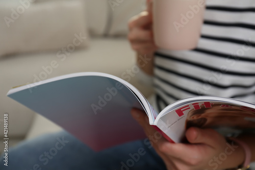 Woman reading sports magazine indoors, closeup view