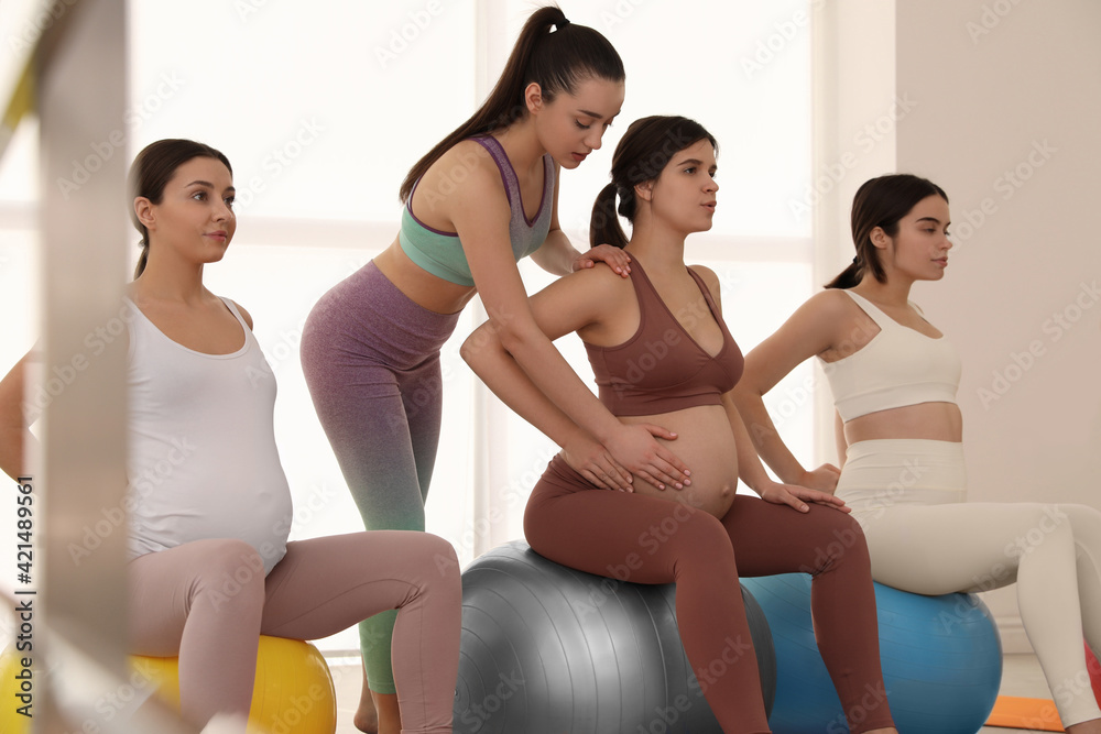 Trainer working with group of pregnant women in gym. Preparation for child birth Trainer working with group of pregnant women in gym. Preparation for child birth