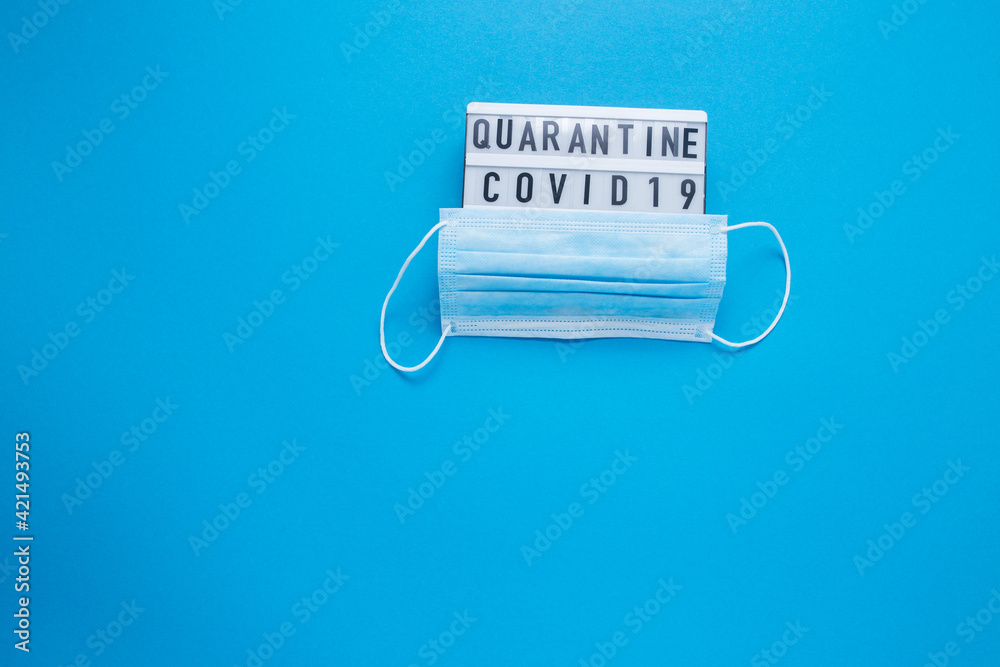 Inscription COVID-19 on blue background. Cube with the inscription. The inscription quarantine. The inscription quarantine. Blue medical mask. Inscription COVID-19 on blue background. Cube with the inscription. The inscription quarantine. The inscription quarantine. Blue medical mask.