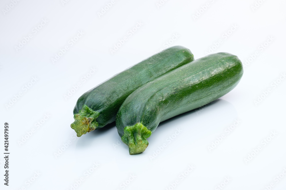 Zwei schöne frische grüne Bio-Zucchini auf einem weißen Hintergrund Zwei schöne frische grüne Bio-Zucchini auf einem weißen Hintergrund