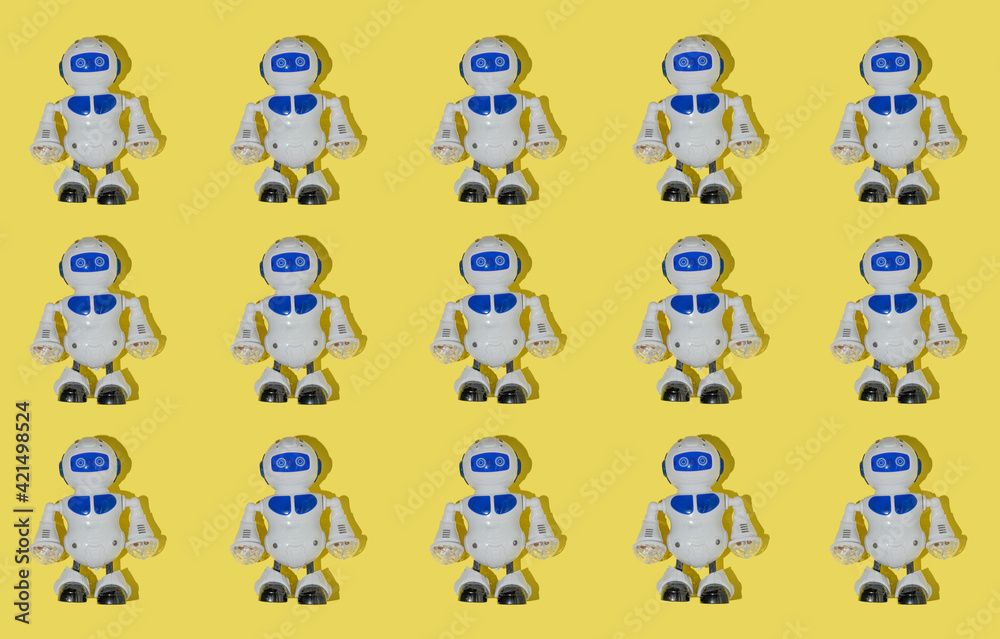 Creative pattern made with robot toy on bright yellow background. Retro style creative composition. Fun idea with childrens toys. Creative pattern made with robot toy on bright yellow background. Retro style creative composition. Fun idea with childrens toys.