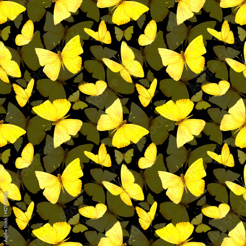 Seamless pattern. Yellow butterflies on a black background. The pattern is suitable for fabric or paper.