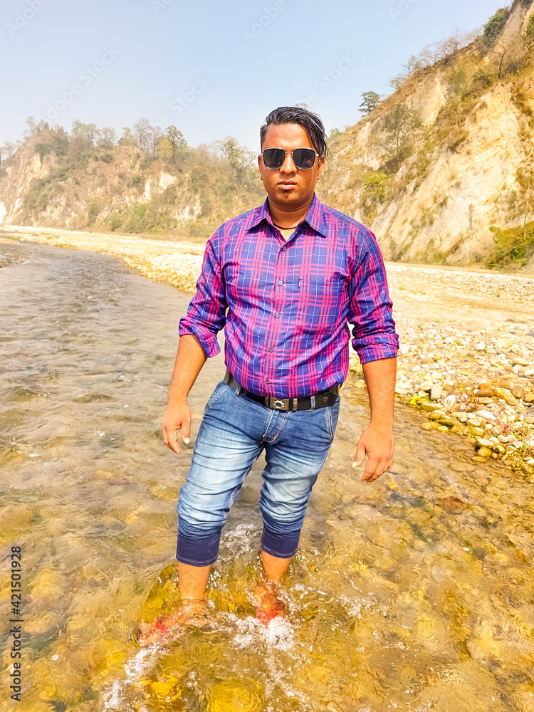 Handsome model man wearing colorful t-shirt with kosi river mountain beautiful background - obrazy, fototapety, plakaty 