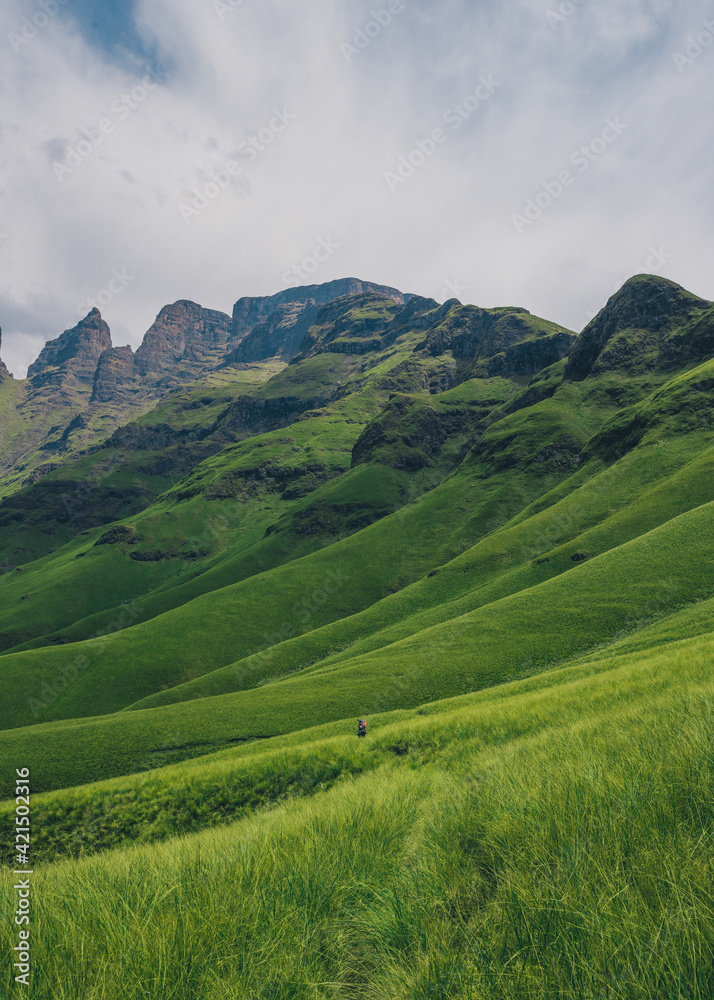 Hiker walking through the valley of Drakensburg, South Africa. October 2019