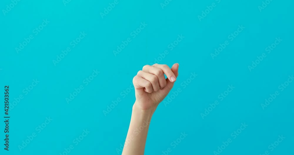 Woman hand points down by elegant finger on turquoise