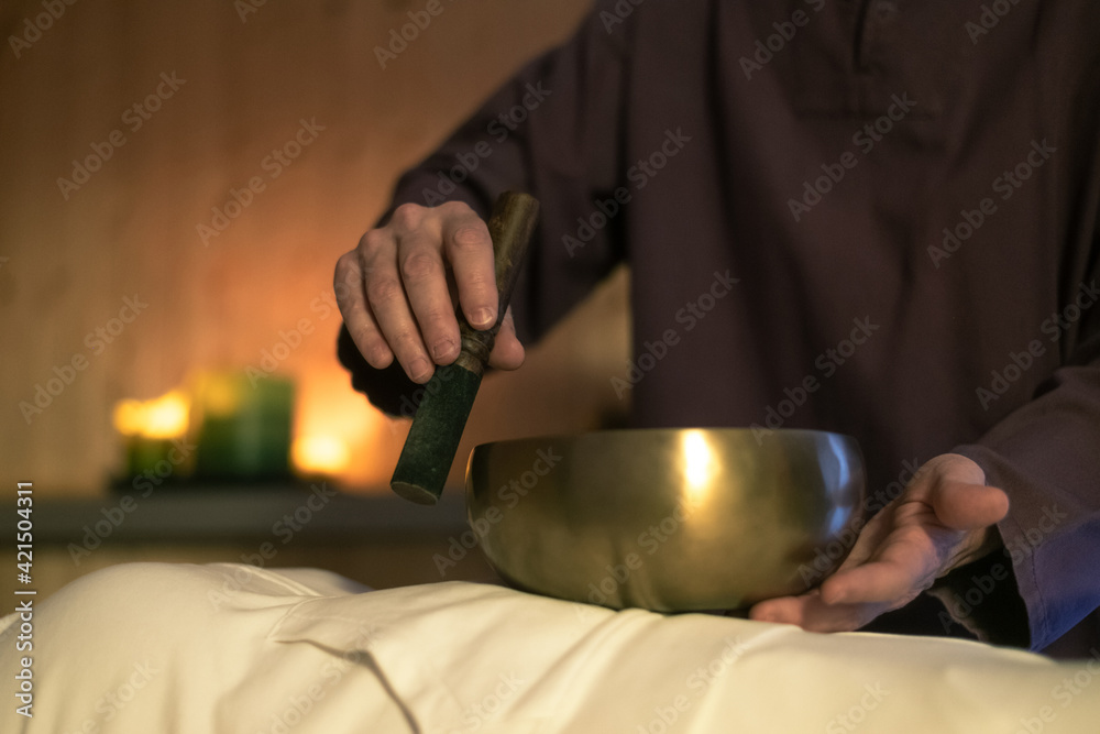 Soft focus view of a woman practicing holistic activities with Tibetan bells. Meditation and mindfulness exercises for calm and clear your mind. Wellness, health, relax, and inner well-being concept.