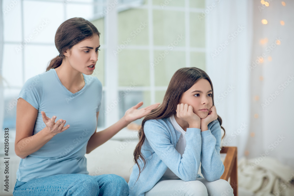 Gesturing angry mom and misunderstanding turned away daughter Gesturing angry mom and misunderstanding turned away daughter