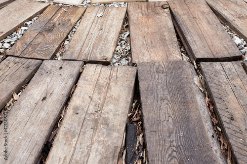 A path made of planks on the ground. Old brown board for background or texture