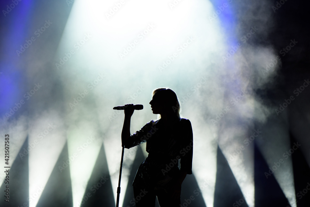 Vocalist singing to microphone. Singer in silhouette