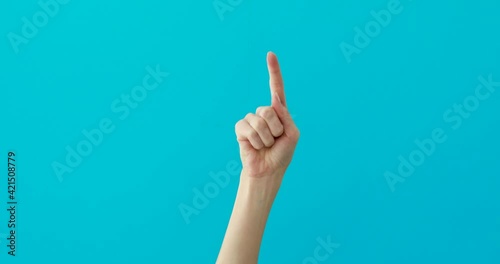 Woman hand points down by elegant finger on turquoise