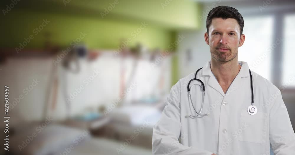 Portrait of caucasian male doctor smiling against hospital in background