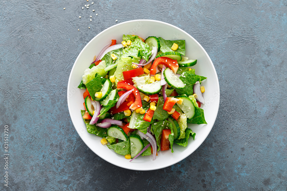Vegetarian fresh vegetable organic salad with cucumber, red bell pepper, red onion, corn and green lettuce Vegetarian fresh vegetable organic salad with cucumber, red bell pepper, red onion, corn and green lettuce