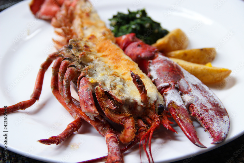 Lobster Thermidor, grilled lobster stuffed with cream and cheese, served with fried potato