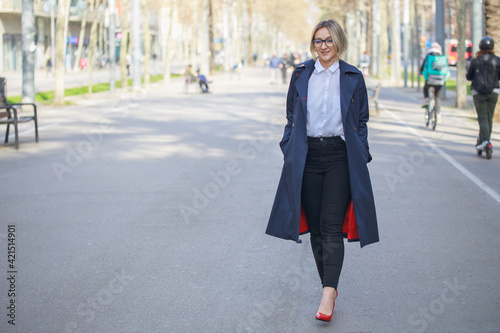 Smiling female entrepreneur walking outside after work.