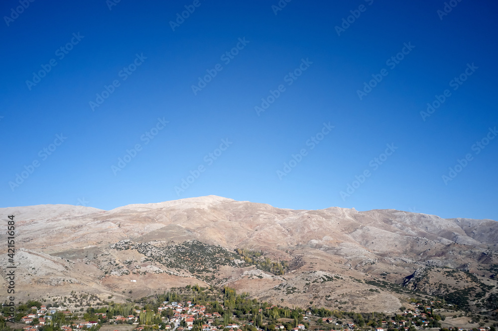 Country landscape with mountain valley on blue sky background.