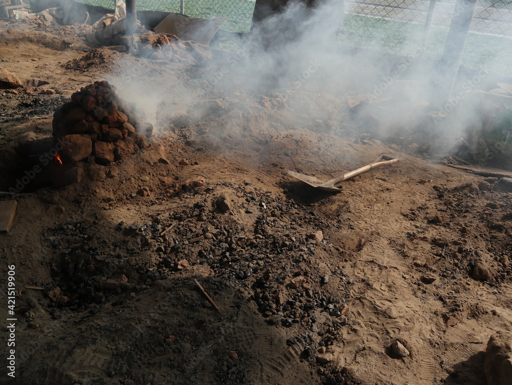 it is a traditional and vintage way to cover food with dirt and burn it by fire to hit the food design for cooking pit concept