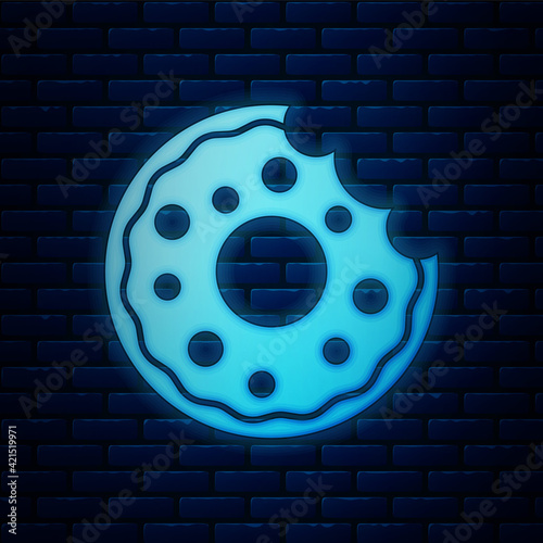 Glowing neon Donut with sweet glaze icon isolated on brick wall background. Vector