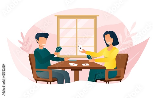 Smiling couple sitting at table and playing card