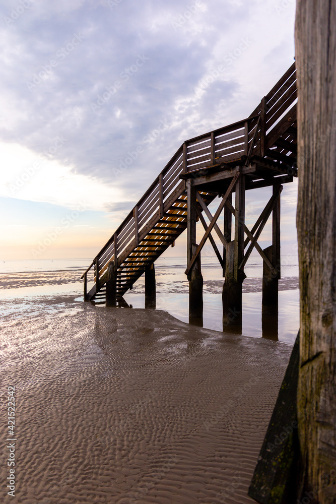 Stairs of stilt houses at the North Sea coast in St. Peter-Ording in Germany during sunset