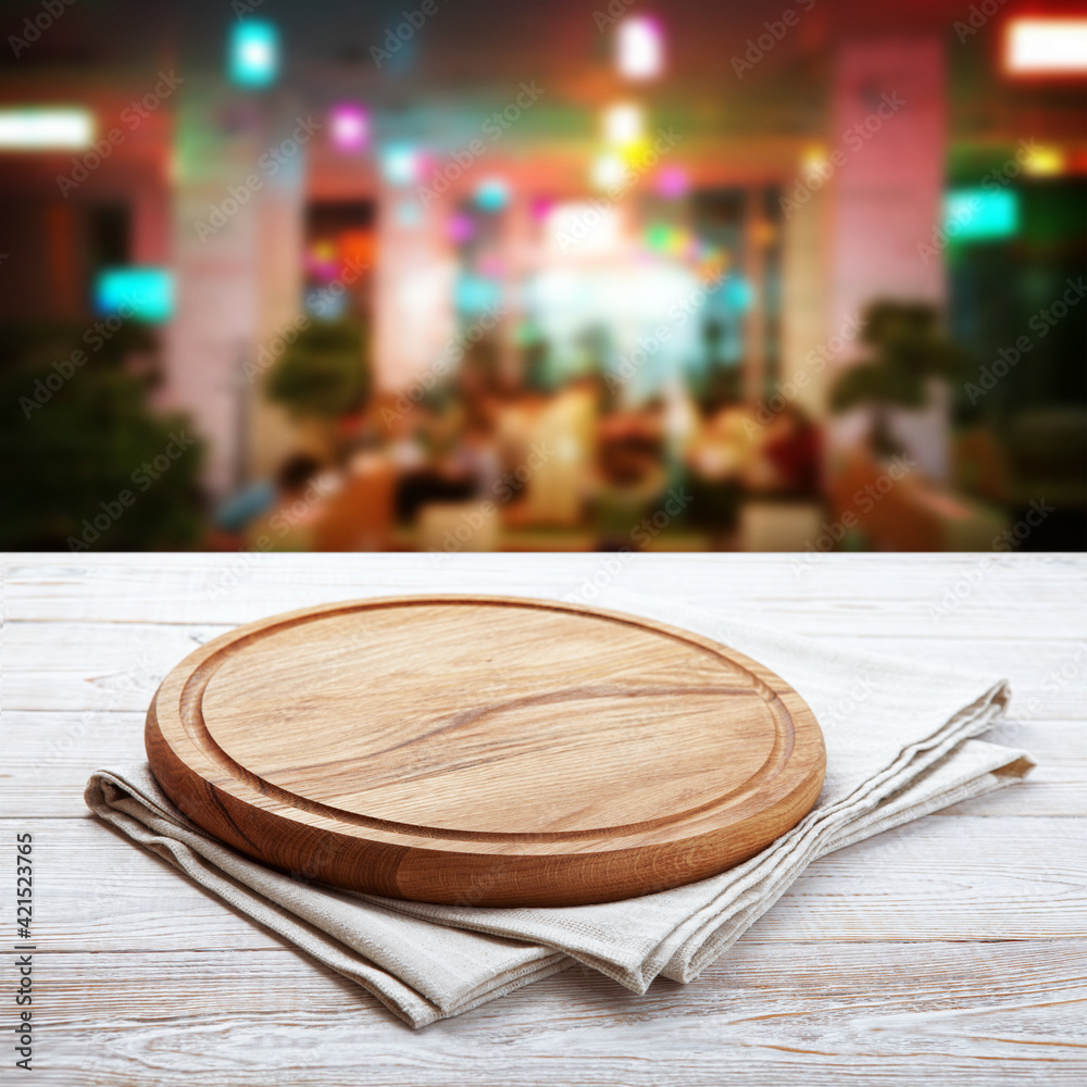 Napkin and pizza board on wooden desk top view mock up. Pizzeria interior. Selective focus.