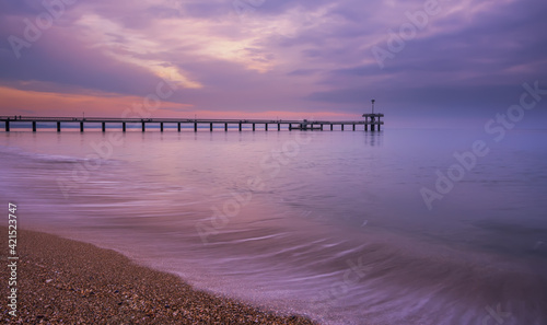 Dramatic sunrise on the beach in Burgas, Bulgaria. Sunrise on the Burgas Bridge. Bridge in Burgas - symbol of the city. 