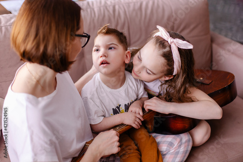 Beautiful portrait of a family with a disabled child. Happy family with a kid cerebral palsy. Lifestyle moments of Real life. Music rehabilitation. activities games leisure together. Inclusion caring