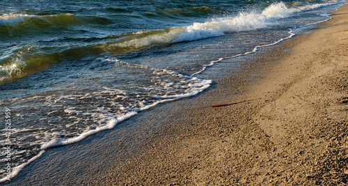 Lake shore with waves during sunset