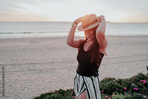 young woman with hat on beach on vacation