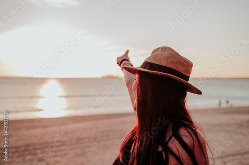 young woman with hat on beach on vacation