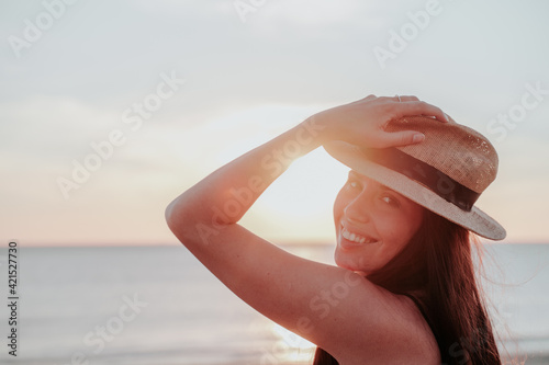 young woman with hat on beach on vacation