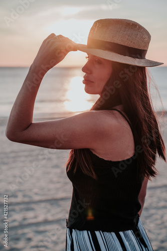 young woman with hat on beach on vacation