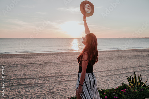 young woman with hat on beach on vacation
