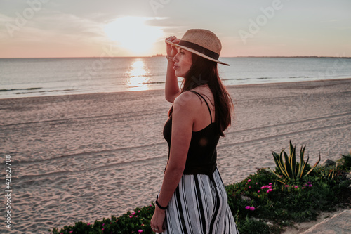 young woman with hat on beach on vacation