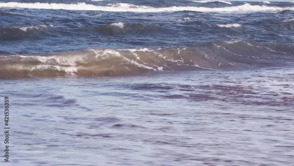 Sea waves crashing against shore during sunlight. Agitated water of ocean. Sea waves crashing against shore during sunlight. Agitated water of ocean.