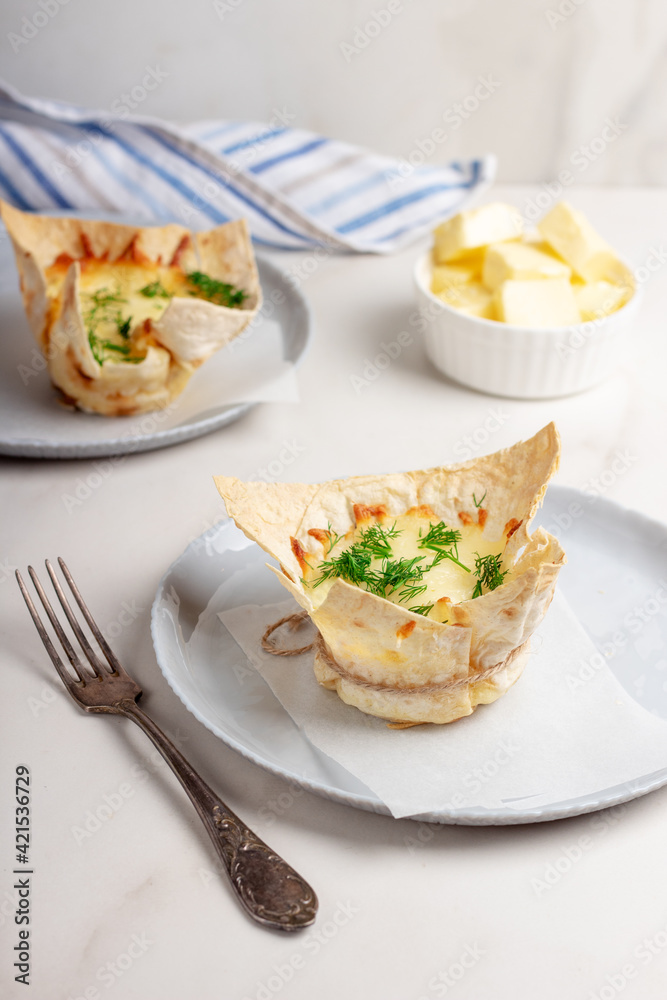 Portioned snack in baked crispy tartlet, lavash with cheese. Delicious appetizer, snack Portioned snack in baked crispy tartlet, lavash with cheese. Delicious appetizer, snack