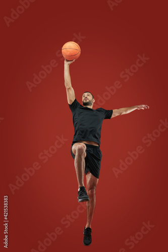 Adult bearded male in black sportswear playing in basketball in sport center © Friends Stock
