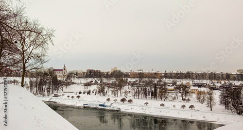 Winter city. A city covered in snow. The ship is off the coast. Embankment, pier.