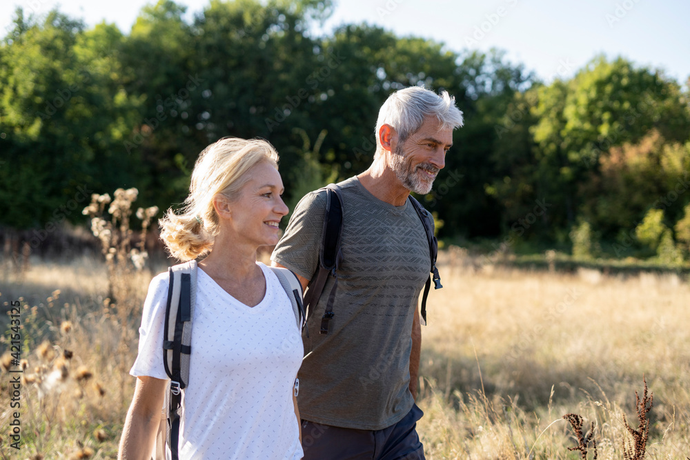 Smiling mature couple hiking in forest Smiling mature couple hiking in forest