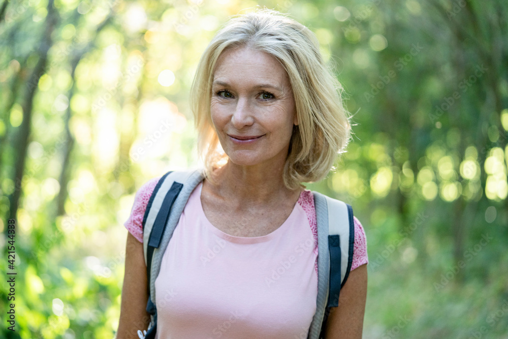 Portrait of smiling mature woman standing in forest Portrait of smiling mature woman standing in forest