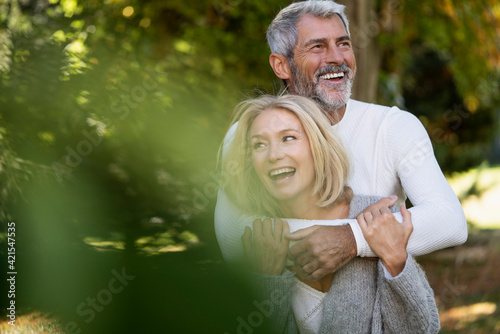Happy mature couple embracing each other in backyard