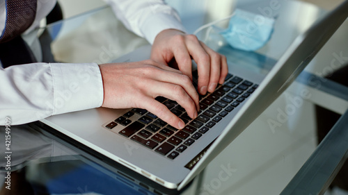 business man typing on a laptop keyboard.