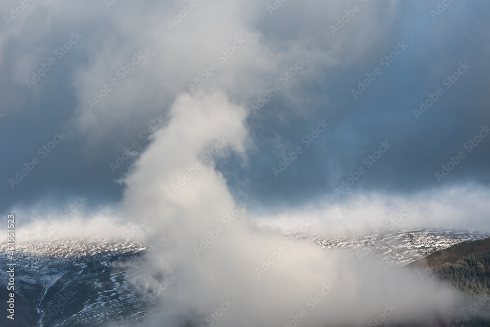 Epic landscape image of Skiddaw snow capped mountain range in Lake District in Winter with low level cloud around peaks viewed from Derwentwater Epic landscape image of Skiddaw snow capped mountain range in Lake District in Winter with low level cloud around peaks viewed from Derwentwater
